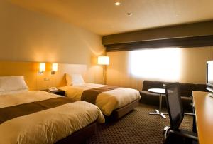 盛冈盛冈大都会酒店的酒店客房,配有两张床和椅子