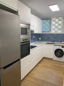马斯帕洛马斯Las olas 214的厨房配有白色橱柜、洗衣机和烘干机