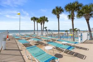 巴拿马城海滩Boardwalk Beach Resort by Panhandle Getaways的海滩上一排躺椅和棕榈树