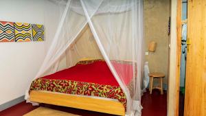 RuhengeriRoom in Guest room - Isange Paradise Resort的一张带天蓬的床