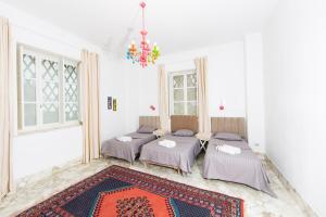拉马萨Appartement privé dans une grande maison d'hote的一间有地毯的房间的四张床