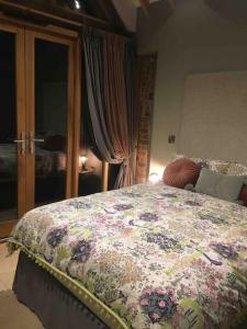Luxury private FARM BARN, Airport, NEC的一间卧室配有一张带花卉床罩的床