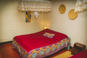 RuhengeriRoom in Guest room - Isange Paradise Resort的一间在房间内配有红色床的卧室