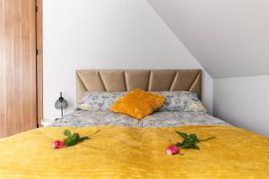 ManiowyJaki Widok!的一张黄色毯子和两朵鲜花的床
