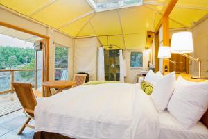锡谢尔特月半湾度假酒店的一间带一张白色大床的卧室和一个阳台