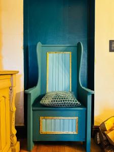 兰特威特梅杰Nightingale Cottage的蓝色的椅子和蓝色的墙上的镜子