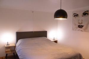 海斯特奥普登贝尔赫Vakantiewoning 't Bruggeneindje的一间卧室配有一张带2个床头柜和2盏灯的床。