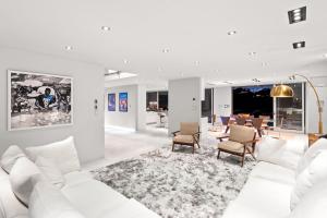 洛杉矶Hollywood Hills Luxury Modern Home with Pool & Sunset views的白色的客厅配有白色的沙发和椅子