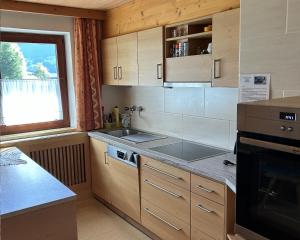 索尔登春居度假屋的厨房配有木制橱柜和炉灶烤箱。
