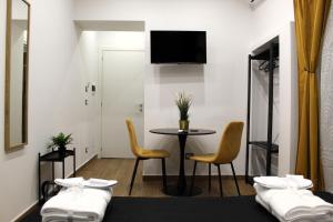那不勒斯BlackWoody Contemporary Rooms - Napoli Centro Storico的一间设有两张床和一张桌子及椅子的房间