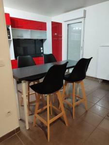 阿蒂斯蒙斯F4 - Duplex spacieux proche d'Orly的红色橱柜厨房里的桌椅