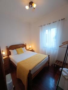 蒙考Casa 42的一间卧室配有一张带黄色毯子和窗户的床