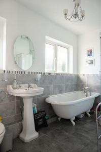 普里茅斯Ocean City Family Home的一间带水槽、浴缸和镜子的浴室