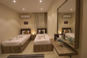 开罗Loca Pyramids View的酒店客房,设有两张床和镜子
