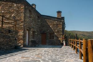 阿加尼尔Casas do Oiteirinho的石头建筑,设有门廊和木栅栏