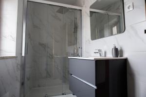 阿加尼尔Casas do Oiteirinho的带淋浴和盥洗盆的浴室