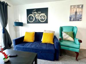 斯劳Bright & Spacious Flat - Perfect for Exploring London , Slough & Windsor!的客厅配有蓝色沙发和绿色椅子