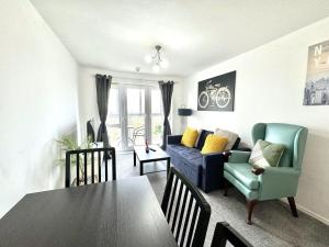斯劳Bright & Spacious Flat - Perfect for Exploring London , Slough & Windsor!的客厅配有桌子和蓝色沙发