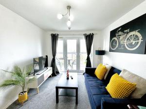 斯劳Bright & Spacious Flat - Perfect for Exploring London , Slough & Windsor!的客厅配有蓝色的沙发和黄色的枕头。