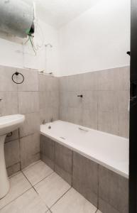 德班Wavecrest 301 Holiday Apartment的带浴缸和盥洗盆的浴室