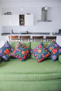 布塞里亚斯Refugio del Mar Luxury Hotel Boutique的绿色沙发上配有4个色彩缤纷的枕头