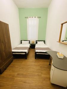 特拉布洛斯City Hostel Dormitory的一间医院间,配有两张床和一张书桌
