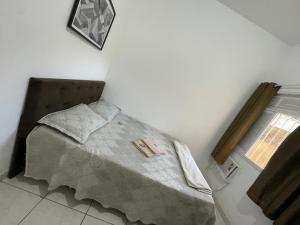 坎普斯戈伊塔卡济斯Status Casa Pelinca的一间卧室配有一张带毯子的床和窗户