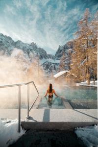 科尔福索Kolfuschgerhof Mountain Resort的雪中热水浴池中的女人