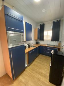 帕拉马里博Kappas place HENDRIKA J VELDKAMPSTRAAT 55的一间小厨房,内配蓝色橱柜和水槽