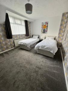 West Midlands Contractors, Nurses and Families的一间卧室设有两张床和窗户。