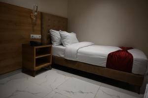 Ouled MoussaMotel Abdelhamid的一间卧室配有一张带红色毯子和床头柜的床