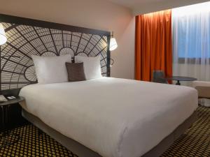 巴黎巴黎凡尔赛门展览中心美居酒店的一张大白色的床,位于酒店客房内