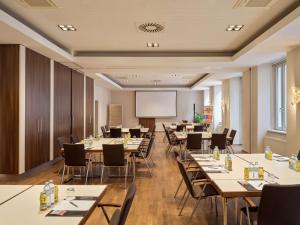维也纳Flemings Selection Hotel Wien-City的一间会议室,配有桌椅和白板