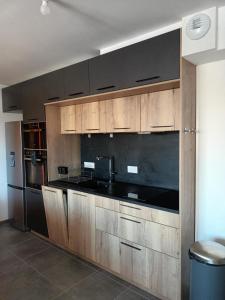 拉菲克拉Spacieux appartement au pied des pistes的厨房配有木制橱柜和黑色台面
