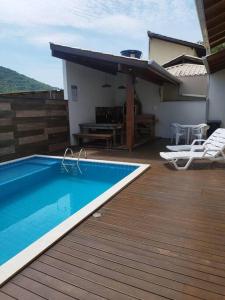 邦比尼亚斯Casa com piscina em Zimbros的房屋内带游泳池的甲板