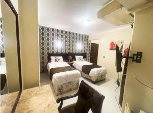赫尔格达Golden Sun Hotel - Hurghada的酒店客房,设有两张床和镜子