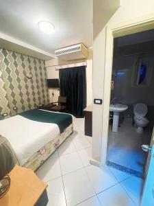 赫尔格达Golden Sun Hotel - Hurghada的一间卧室配有一张床,浴室设有水槽