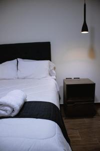 万卡约PRANA的卧室配有白色的床和床头柜