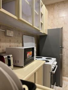 奥朱贝尔شقة سكنية بغرفتين نوم的厨房配有炉灶和微波炉。