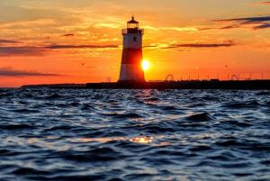 伊利伊利湖湾万怡酒店的海洋上的灯塔,背景是日落