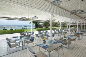 芭东海滩Phuket Marriott Resort & Spa, Merlin Beach的一间在甲板上配有桌椅的餐厅