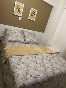 圣路易斯Flat Biarritz em São Luís com excelente localização!的一间卧室配有一张带花卉棉被的床