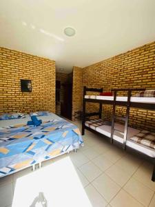 考卡亚Casa do Ric的一间卧室设有两张双层床和砖墙