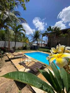 考卡亚Casa do Ric的一座带椅子和黄色花卉的游泳池