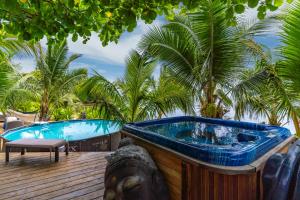 莫雷阿Fare Oaoa Haapiti的棕榈树甲板上的按摩浴缸