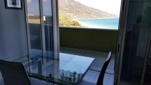 切法卢CH Exclusive Apartments的玻璃间设有桌子,享有海景
