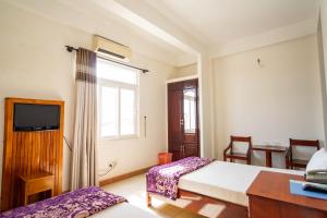 岘港Lyly的一间卧室配有一张床、一张书桌和一个窗户。