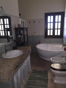 拉古萨罗洛花园住宿加早餐旅馆的一间带两个盥洗盆、浴缸和卫生间的浴室