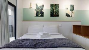 阿雷格里港Charlie Porto Alegre Praça 4的卧室配有一张四幅画的墙壁床。