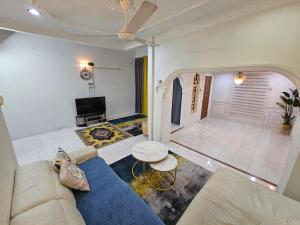 哥打巴鲁Ruhani Homestay 3 KB - 4 Bedroom Fully Airconditioned with WIFI & Netflix的客厅配有蓝色的沙发和电视